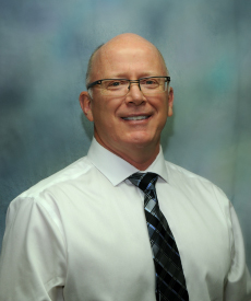 man wearing glasses and tie smiling